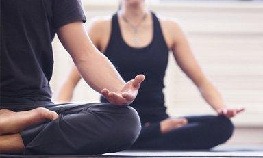 Duas pessoas em pose de ioga ou alongamento para fortalecer os músculos