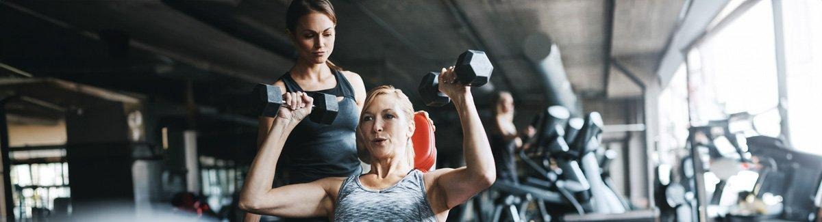 homem adulto com a ajuda de um profissional realiza exercícios de mobilidade ou fortalecimento muscular