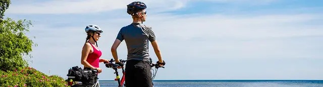 Hombre y mujer con bicicletas admirando paisaje