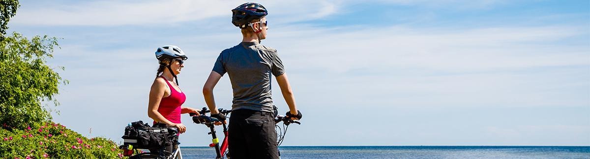 Hombre y mujer con bicicletas admirando paisaje