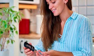 Mulher jovem em um apartamento iluminado, exercitando-se, respirando profundamente, transmitindo saúde, equilíbrio e serenidade.