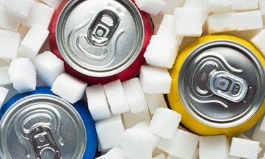 Pessoa em uma mesa, em frente a diferentes alimentos que fornecem carboidratos.