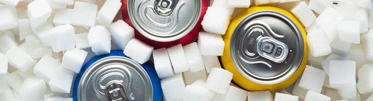 Pessoa em uma mesa, em frente a diferentes alimentos que fornecem carboidratos.