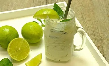 Shake de morango com Glucerna sabor baunilha em copo sobre fundo de madeira com morangos