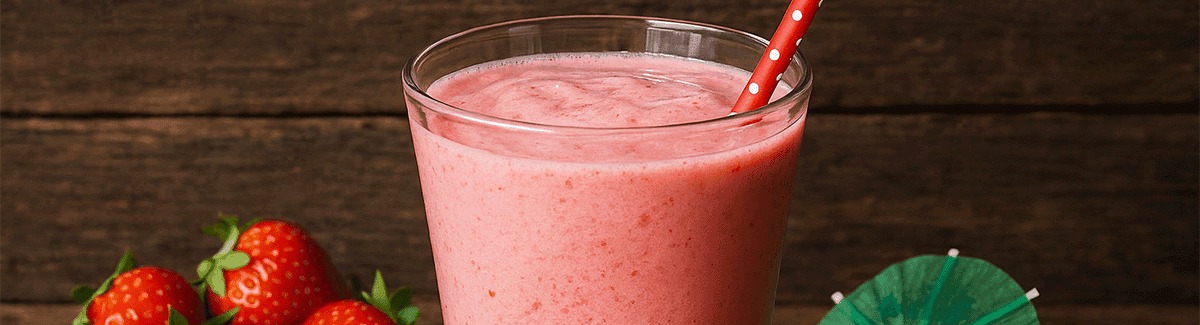 Shake de morango com Glucerna sabor baunilha em copo sobre fundo de madeira com morangos