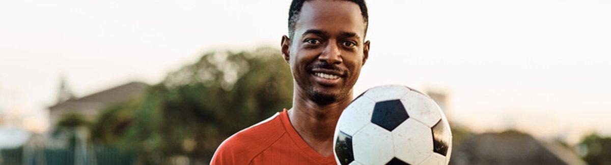 Atleta com uma bola de futebol