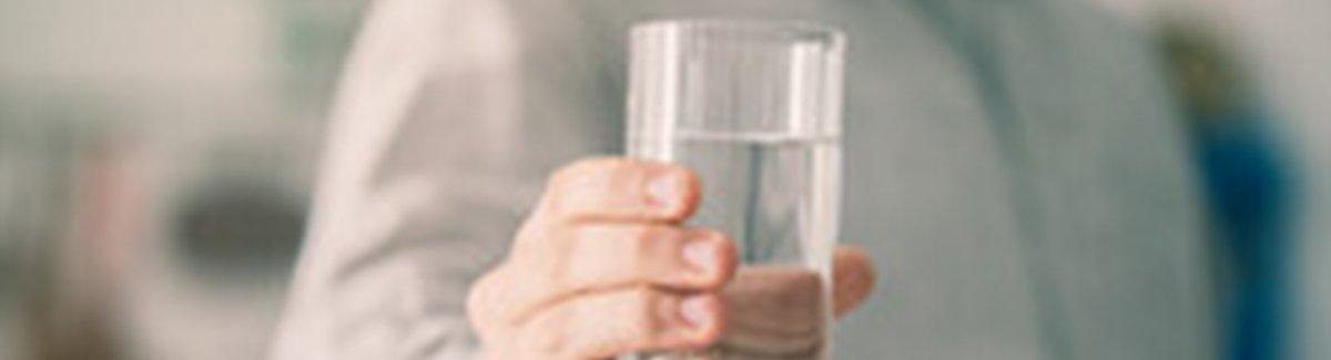 Homem segurando um copo de água