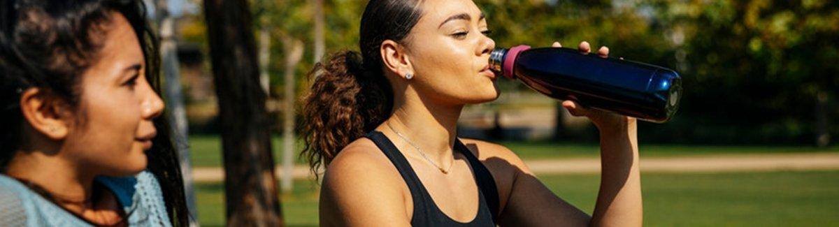 Mulher bebendo água no parque