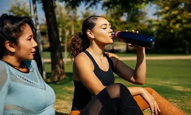 Mulher bebendo água no parque