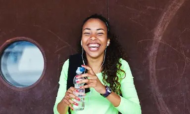 Mulher sorrindo segurando uma garrafa de água